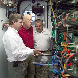 3 men working on equipment.